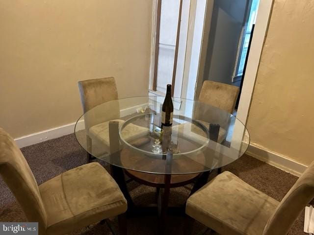 carpeted dining room featuring baseboards