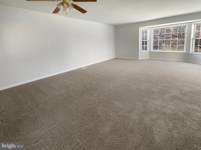 empty room featuring carpet flooring, baseboards, and a ceiling fan