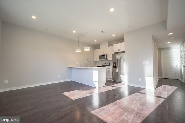 kitchen featuring decorative light fixtures, white cabinetry, stainless steel appliances, dark hardwood / wood-style floors, and kitchen peninsula