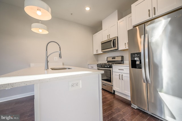 kitchen featuring white cabinets, appliances with stainless steel finishes, a center island with sink, and sink