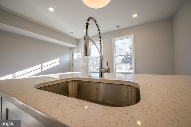 details featuring light stone countertops and sink