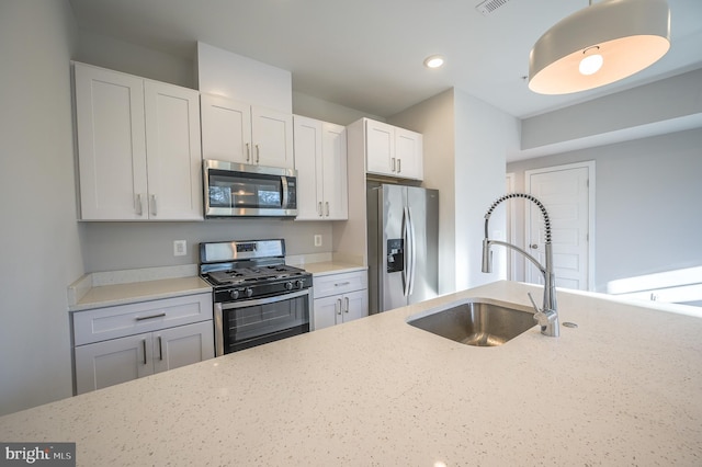 kitchen featuring light stone counters, sink, white cabinetry, and stainless steel appliances