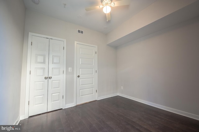 unfurnished bedroom with ceiling fan and dark hardwood / wood-style flooring