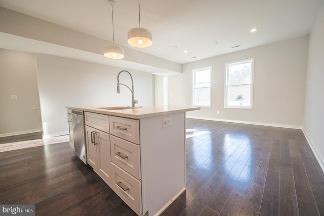 kitchen with an island with sink, dark hardwood / wood-style flooring, dishwasher, pendant lighting, and sink