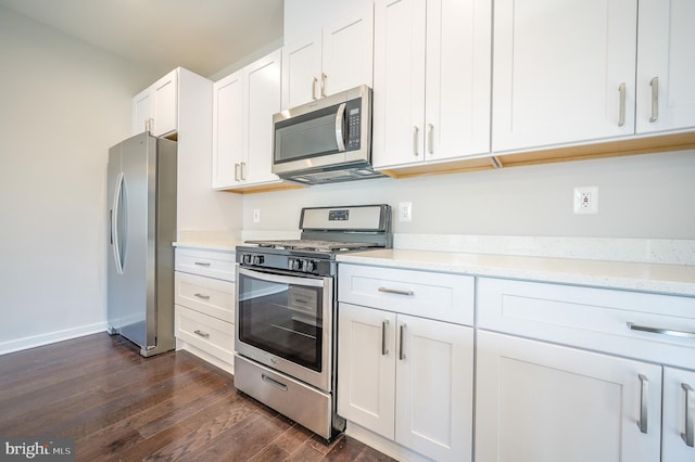 kitchen featuring light stone countertops, appliances with stainless steel finishes, dark hardwood / wood-style flooring, and white cabinetry