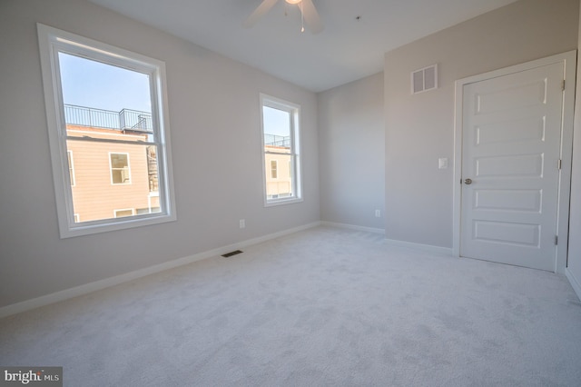 carpeted spare room with ceiling fan