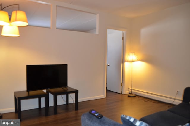 living room with a baseboard heating unit and dark hardwood / wood-style flooring