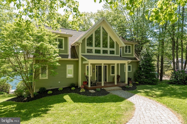 rear view of house with a porch and a yard