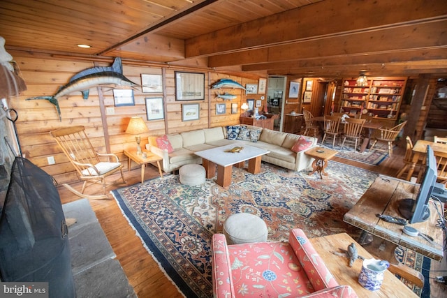 living room with hardwood / wood-style floors, wooden ceiling, beam ceiling, and wood walls