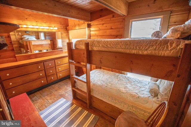 bedroom with wood ceiling, wood-type flooring, beam ceiling, and wood walls