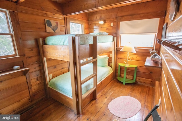 bedroom featuring wood-type flooring and wood walls