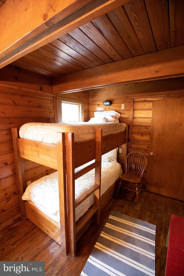 bedroom with dark wood-type flooring, wood ceiling, and wood walls