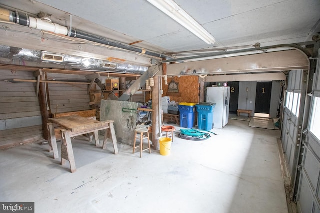 basement featuring white fridge with ice dispenser