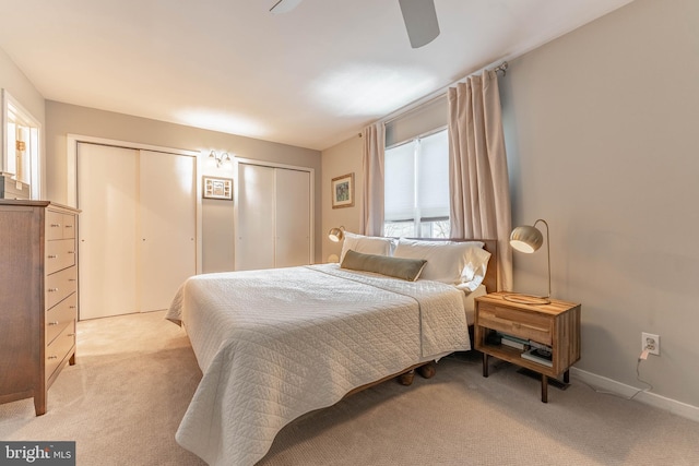 bedroom with multiple closets, light colored carpet, baseboards, and a ceiling fan