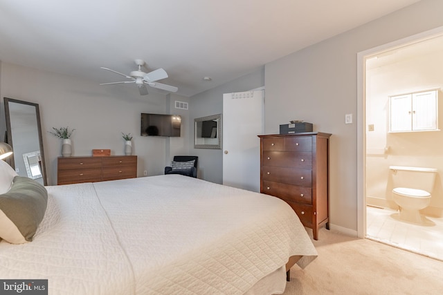 bedroom featuring visible vents, a ceiling fan, light colored carpet, ensuite bath, and vaulted ceiling