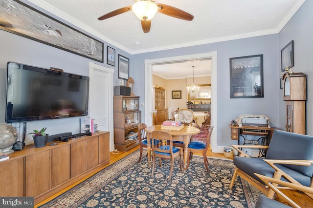 dining room with ceiling fan with notable chandelier, ornamental molding, and light wood-style floors