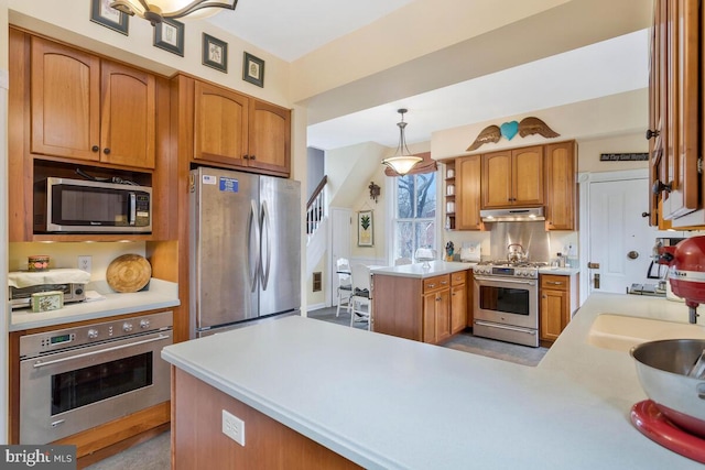 kitchen with decorative light fixtures, stainless steel appliances, light countertops, a peninsula, and under cabinet range hood