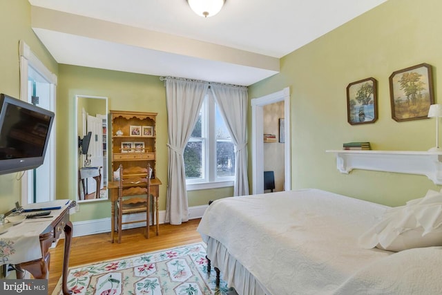 bedroom featuring light wood-style floors and baseboards