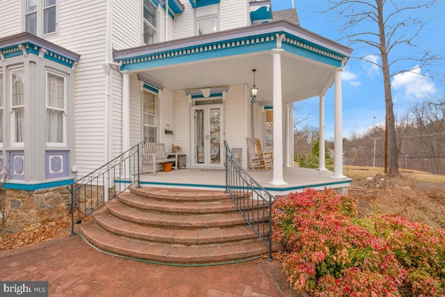 view of exterior entry featuring covered porch