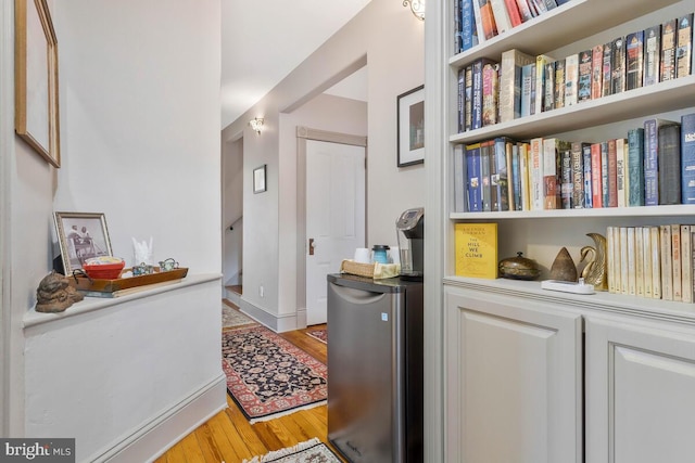 hallway with light wood-style flooring and baseboards