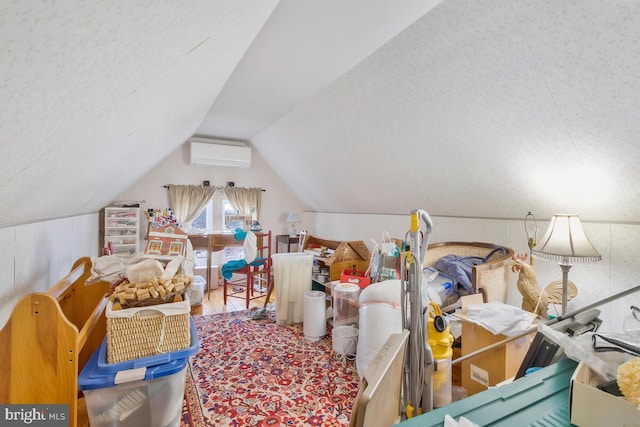 interior space featuring lofted ceiling, an AC wall unit, and wood finished floors