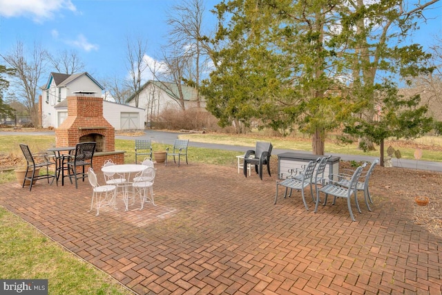 view of patio / terrace with an outdoor brick fireplace and outdoor dining area