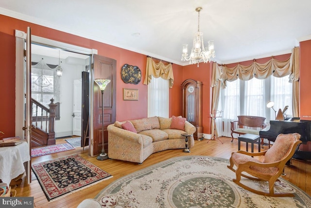 living room featuring light wood-type flooring, an inviting chandelier, and stairway