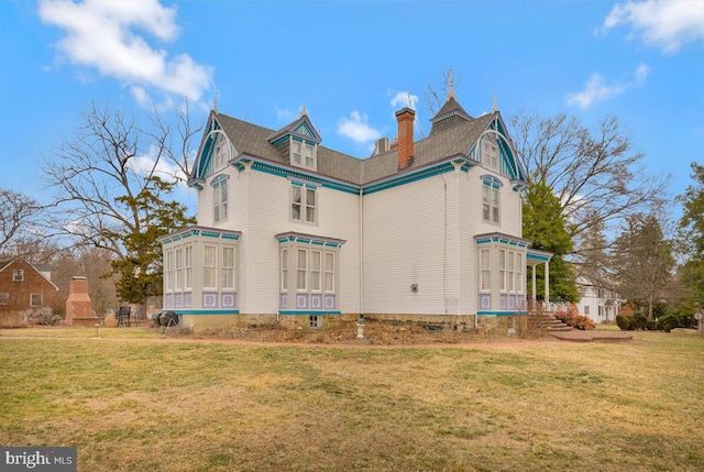 view of side of home with a lawn and a chimney