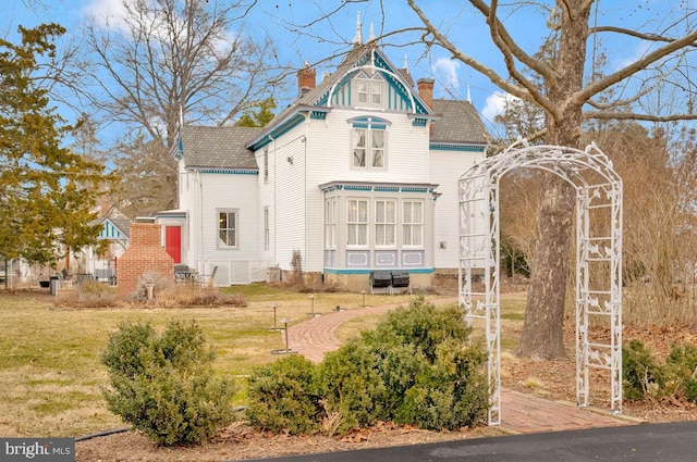 exterior space with a chimney and a front lawn