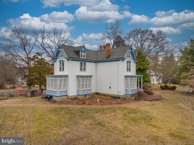 rear view of house featuring a lawn