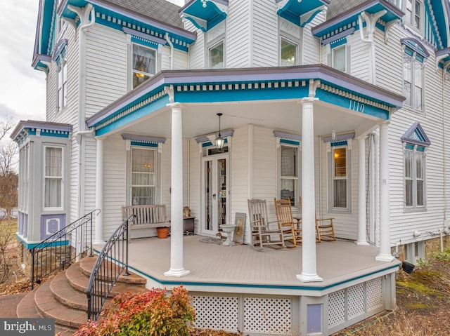 exterior space with a porch and roof with shingles