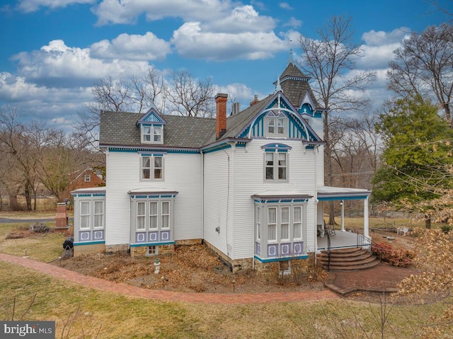 back of house featuring a chimney