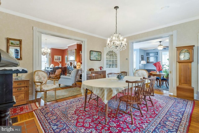 dining room featuring ornamental molding, wood finished floors, and an inviting chandelier