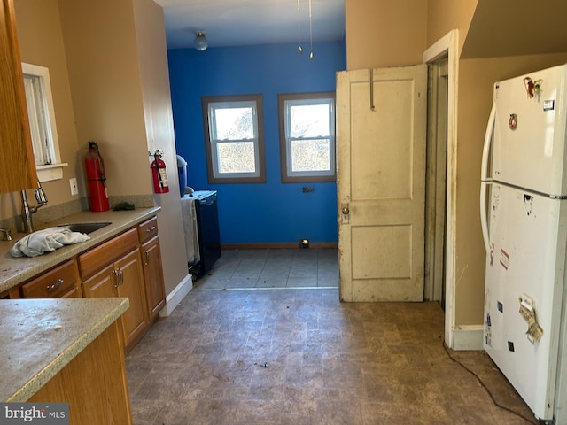 kitchen featuring white refrigerator and sink