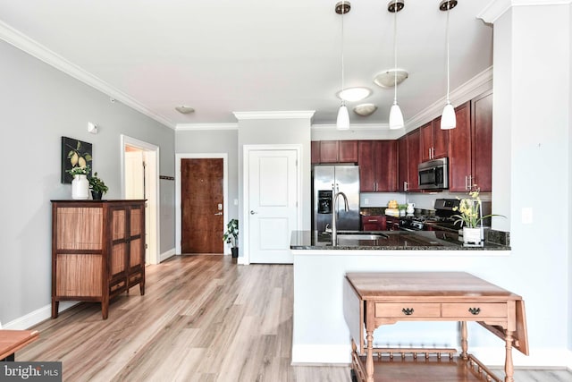 kitchen with kitchen peninsula, appliances with stainless steel finishes, pendant lighting, crown molding, and sink