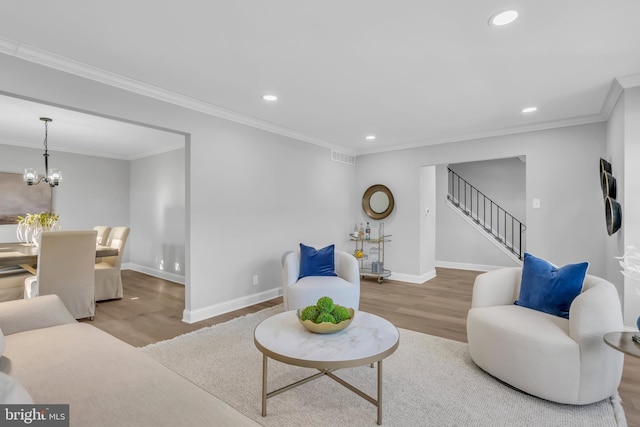 living room featuring crown molding, hardwood / wood-style flooring, and a notable chandelier