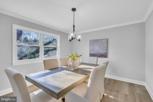 dining room featuring crown molding, wood-type flooring, and an inviting chandelier