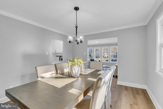 dining room with a chandelier, ornamental molding, and light hardwood / wood-style flooring