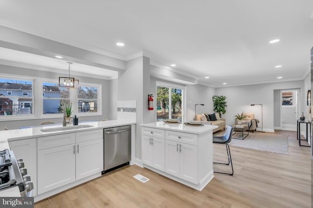 kitchen featuring decorative light fixtures, light hardwood / wood-style floors, kitchen peninsula, appliances with stainless steel finishes, and white cabinets