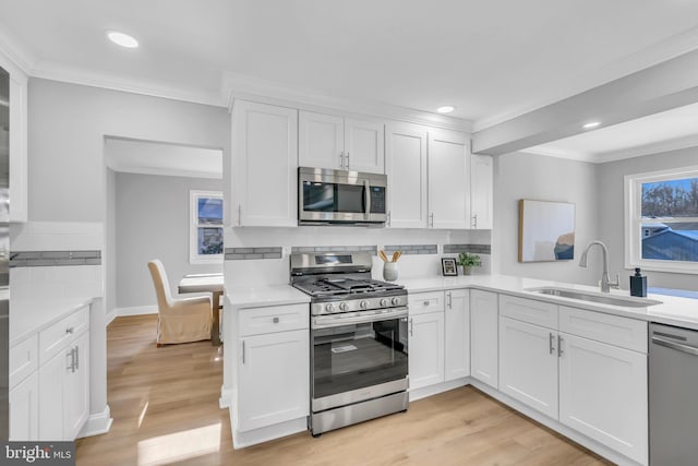 kitchen with sink, white cabinetry, and stainless steel appliances