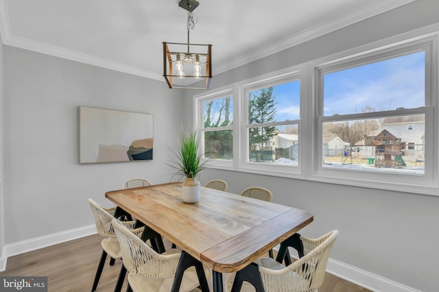 dining area with an inviting chandelier, crown molding, and wood-type flooring