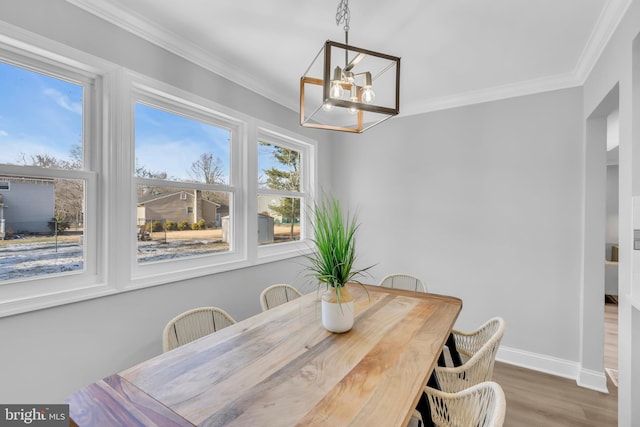 dining space with crown molding, a chandelier, and hardwood / wood-style floors