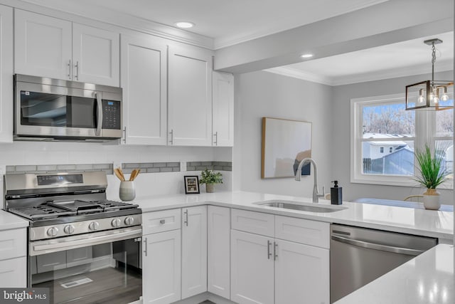 kitchen featuring white cabinets, appliances with stainless steel finishes, decorative backsplash, sink, and crown molding