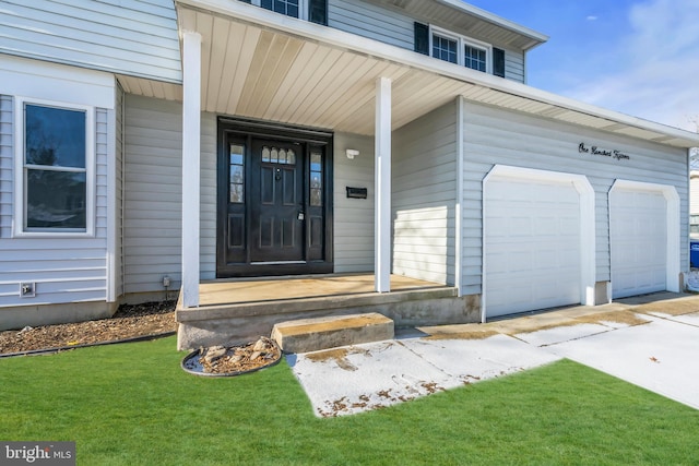 entrance to property with a garage and a lawn