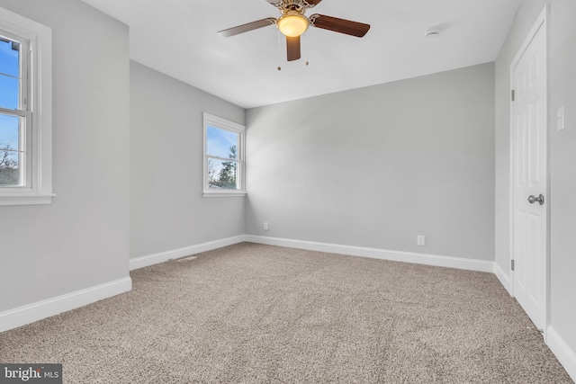 carpeted spare room featuring ceiling fan