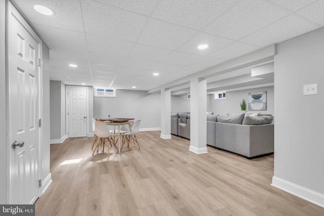 unfurnished dining area featuring light hardwood / wood-style floors and a drop ceiling