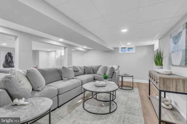 living room with light wood-type flooring and a drop ceiling