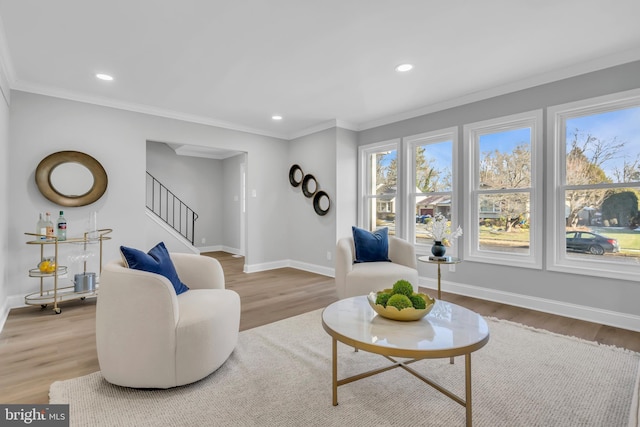 living room with light wood-type flooring and ornamental molding