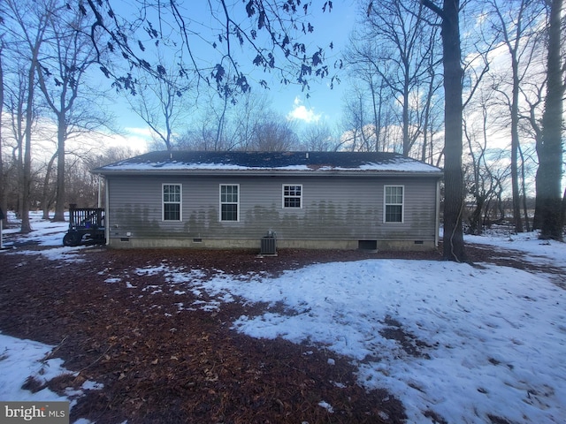 snow covered property with central AC