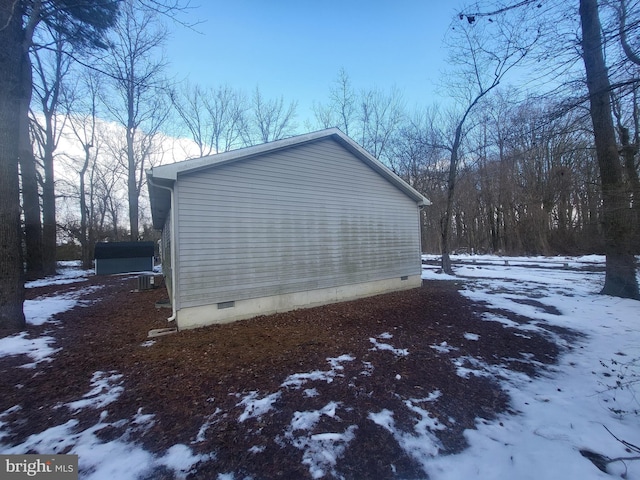 view of snowy exterior featuring a shed